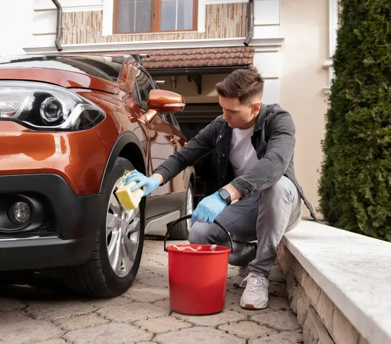 Lavage auto à domicile Champagnac-de-Belair : professionnel intervenant sur un véhicule
